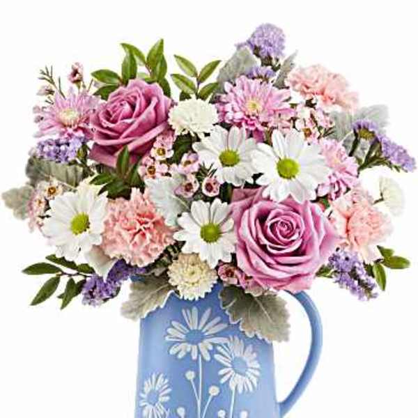Pink roses and daisies arranged in a blue pitcher vase