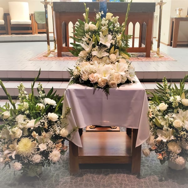 White floral arrangements around a church altar