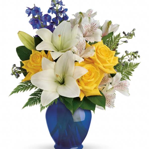 Bouquet of yellow roses and white lilies in a blue vase