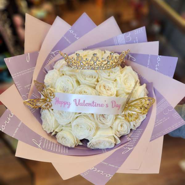 Bouquet of white roses with a jeweled crown and butterfly decorations