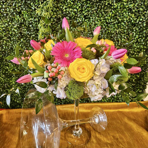 Pink and yellow flower arrangement in a clear glass vase