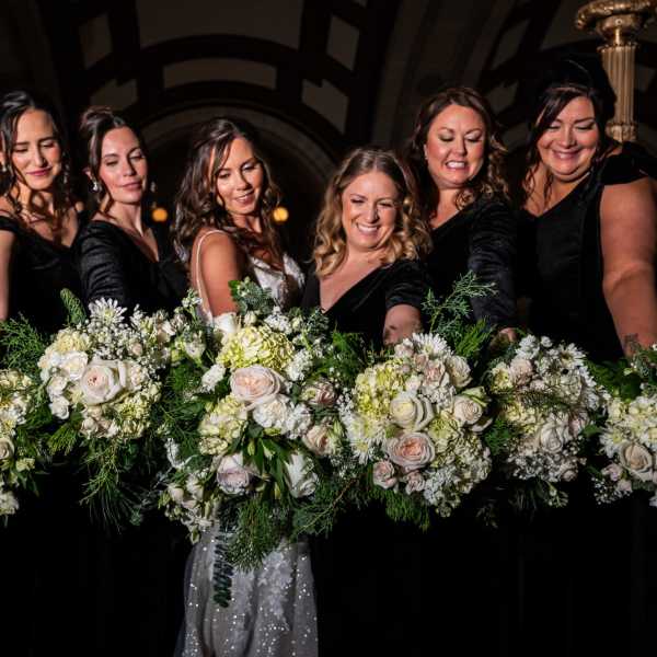 Bridesmaids holding white and blush floral bouquets