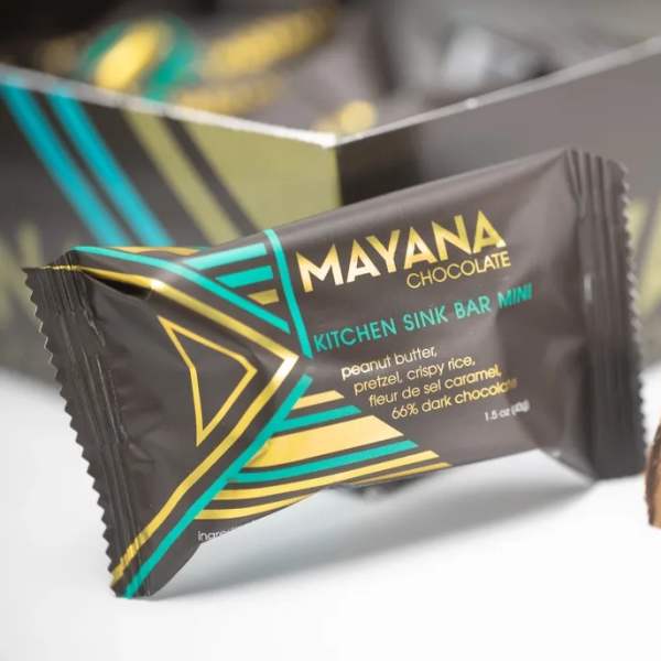 Wrapped chocolate bar with a cut piece showing caramel and nuts