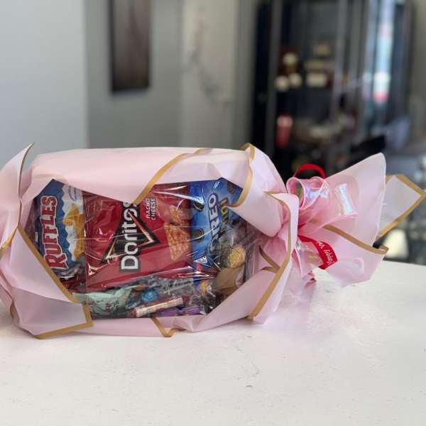 Candy bouquet wrapped in pink paper with ribbon bows