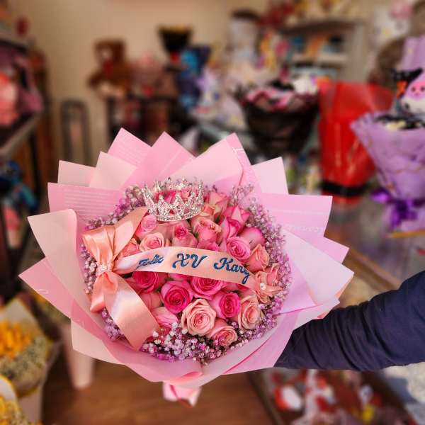 Pink rose bouquet with a ribbon and jeweled crown topper
