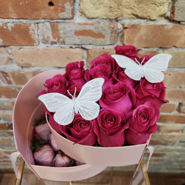Pink rose bouquet in a round box with white butterfly decorations