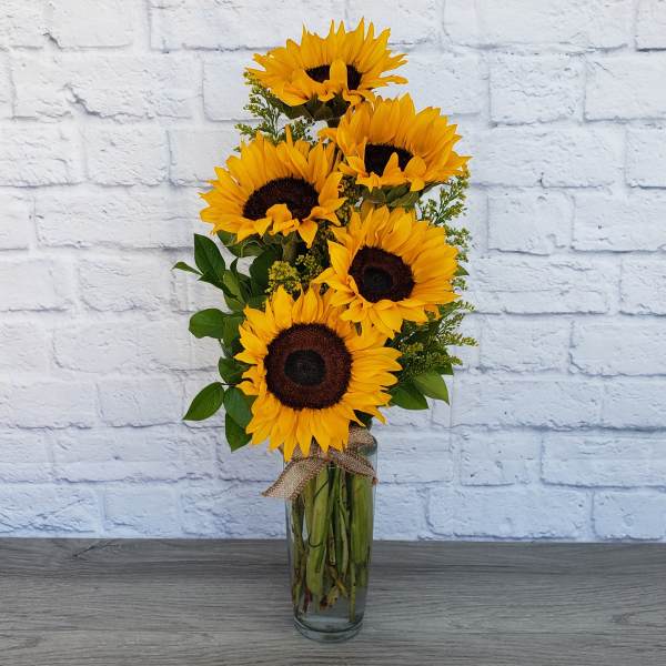 Tall bouquet of sunflowers in a clear glass vase