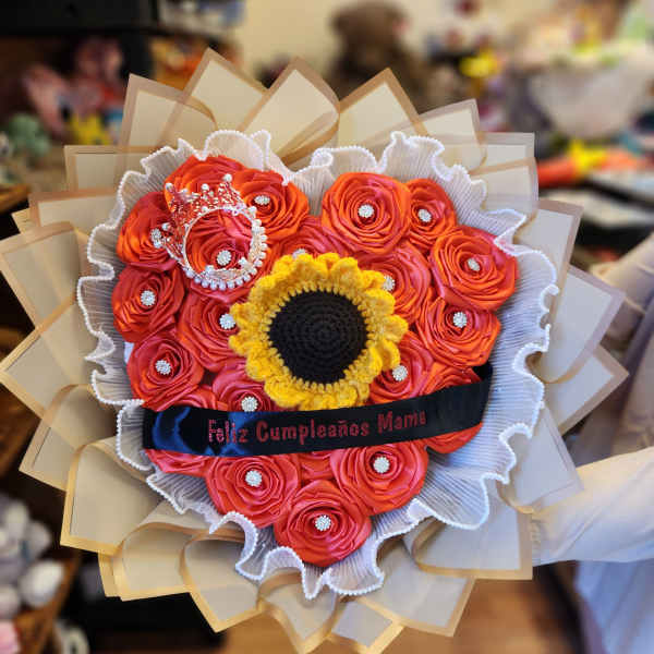 Bouquet of orange roses with a sunflower center and a crown topper