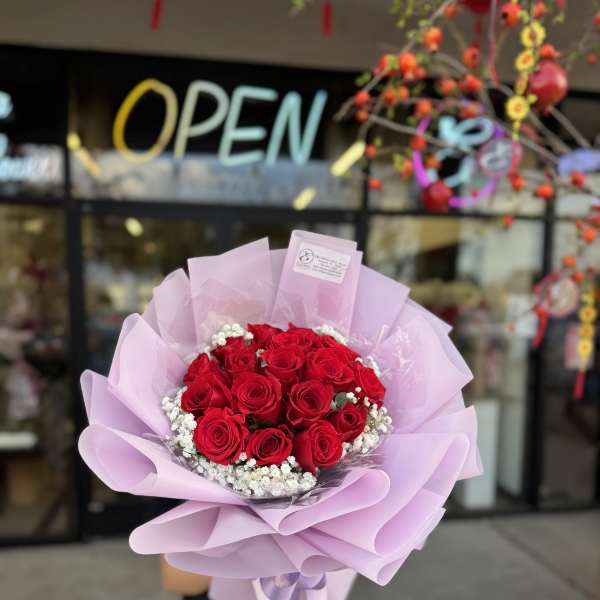 Bouquet of red roses wrapped in light pink paper