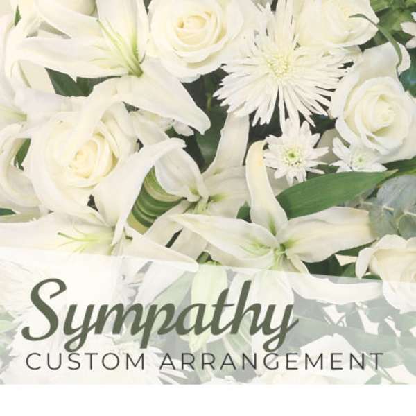 White roses and lilies with daisy-like blooms in a sympathy arrangement