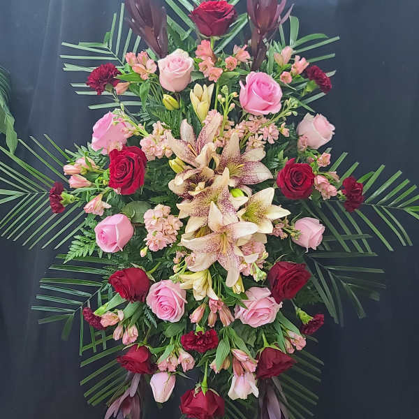 Standing floral spray with roses and lilies on an easel