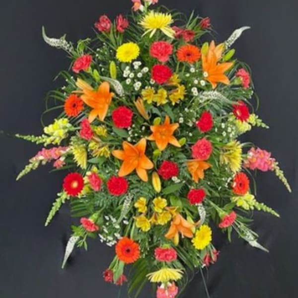 Tall standing floral spray with orange, red, and yellow blooms