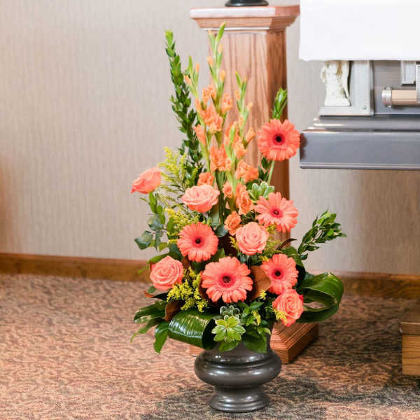 Coral gerberas and roses in a dark vase