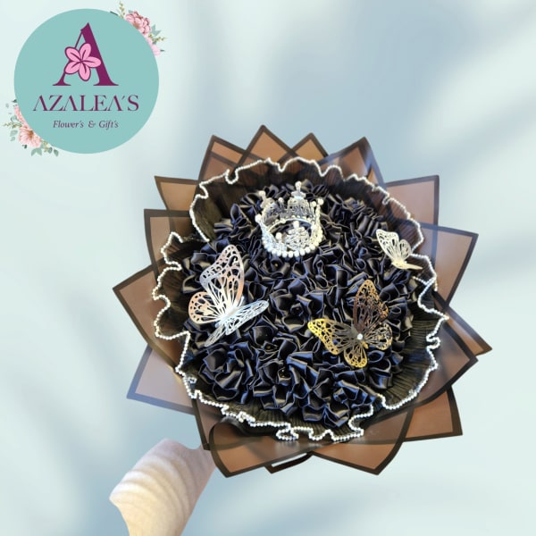 Black decorative bouquet with butterfly accents and a crown topper