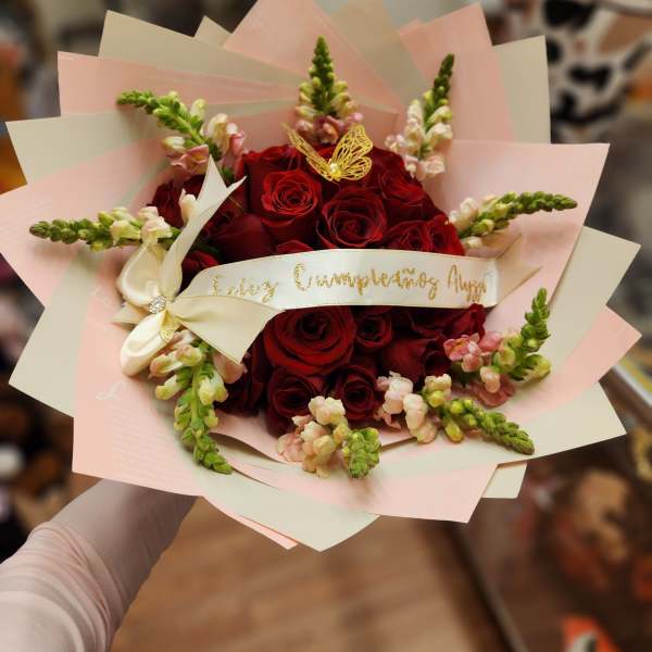 Bouquet of red roses with pink snapdragons and a cream ribbon