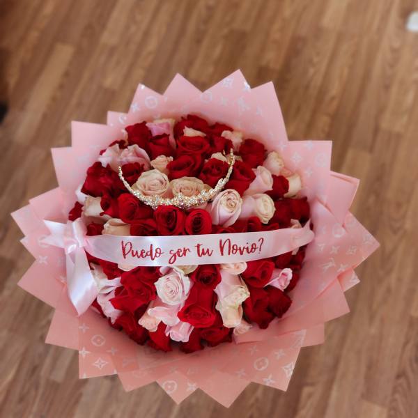 Bouquet of red and blush roses with a pink ribbon and tiara