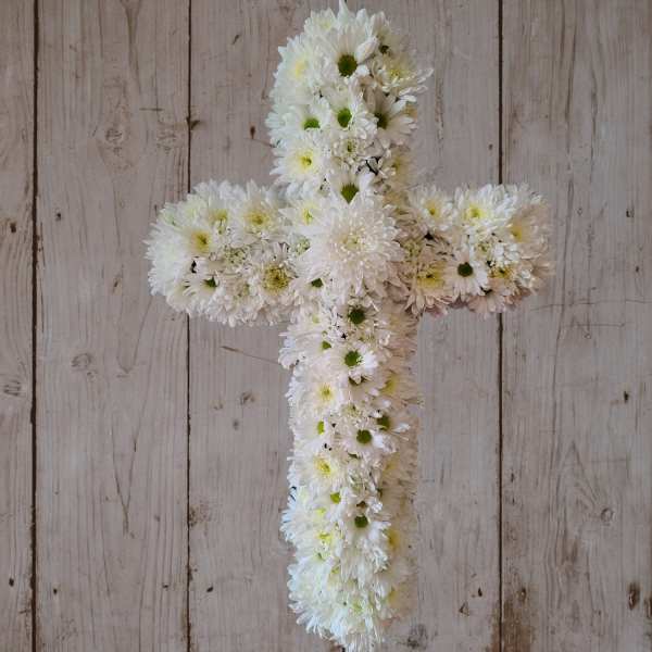White daisy cross arrangement on a rustic wood background