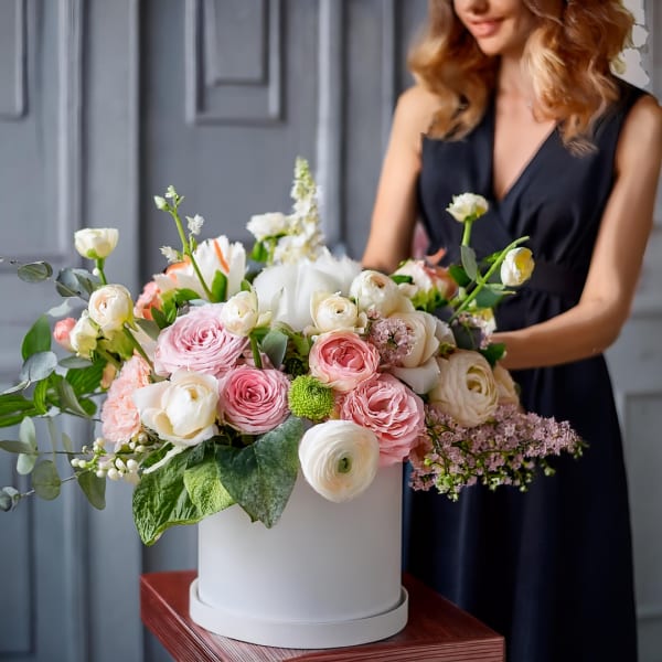Large pink and white flower arrangement in a white box