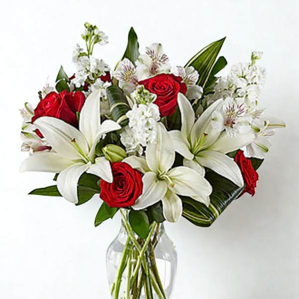 Red roses and white lilies in a clear glass vase
