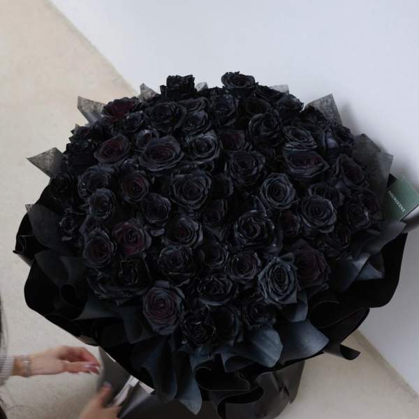 Large bouquet of black roses wrapped in dark paper