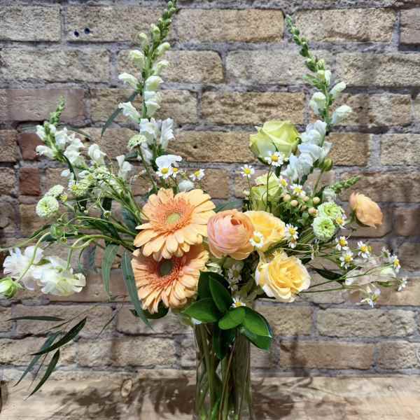 Peach and yellow mixed bouquet in a clear glass vase