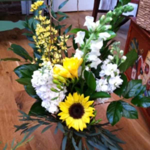 Bouquet with a sunflower, white blooms, and yellow flowers in a vase