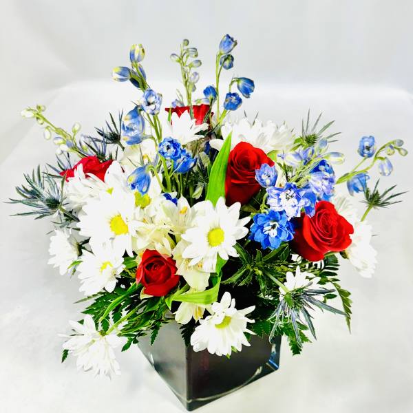 Red roses, white daisies, and blue flowers in a black vase