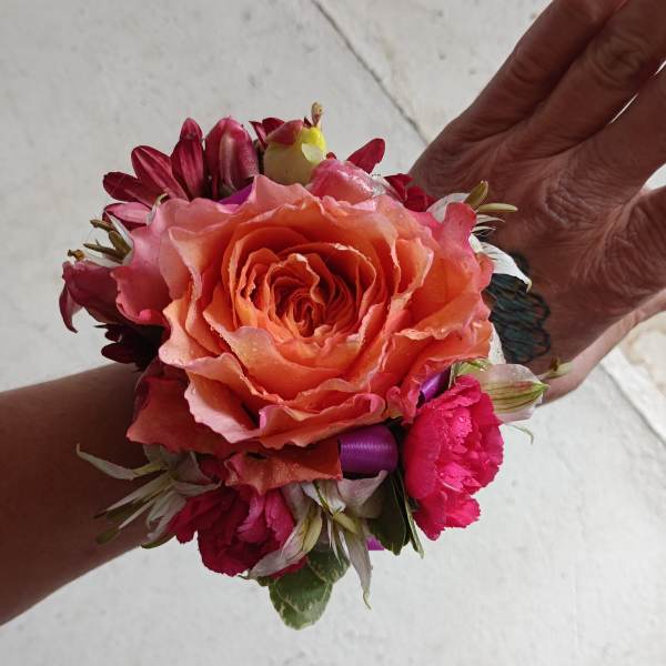 Handheld corsage with a peach rose and pink flowers