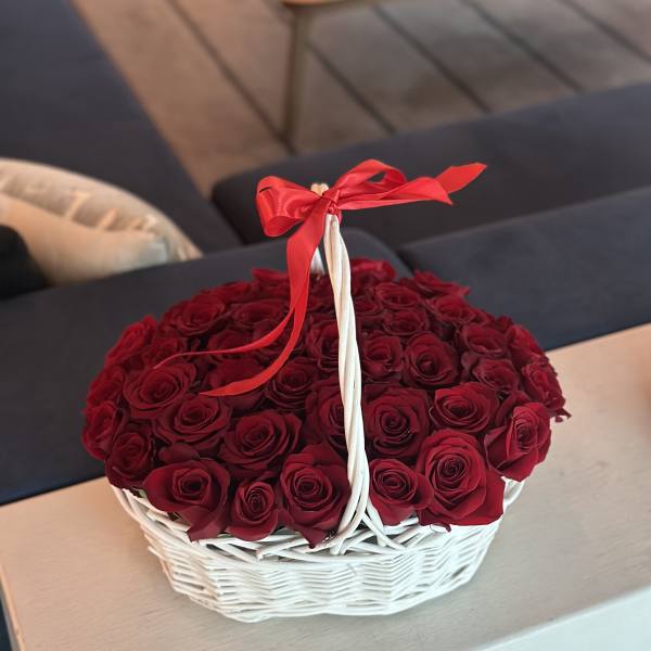 Basket of red roses tied with a red ribbon