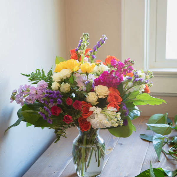 Mixed bouquet of colorful flowers in a clear glass vase