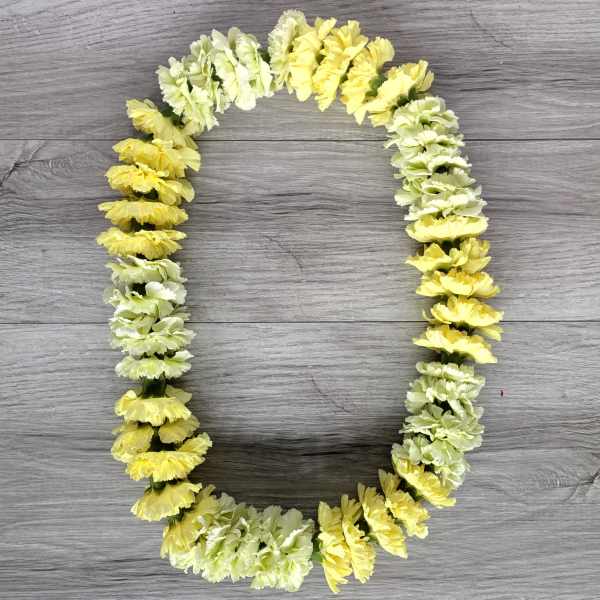 Yellow and pale green flower garland arranged in an oval on a wood surface