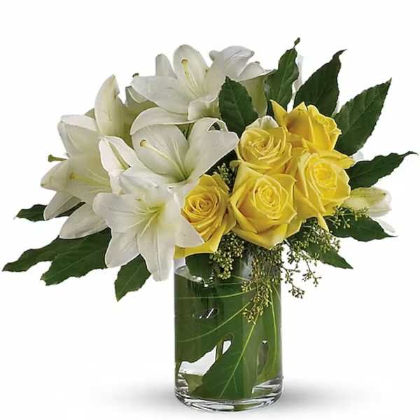 White lilies and yellow roses in a clear glass vase