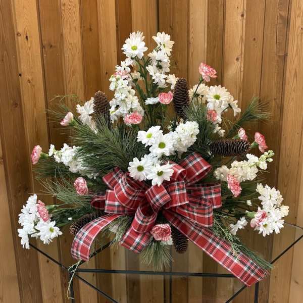 Christmas floral arrangement with white daisies, pink carnations, pinecones, and a red plaid bow