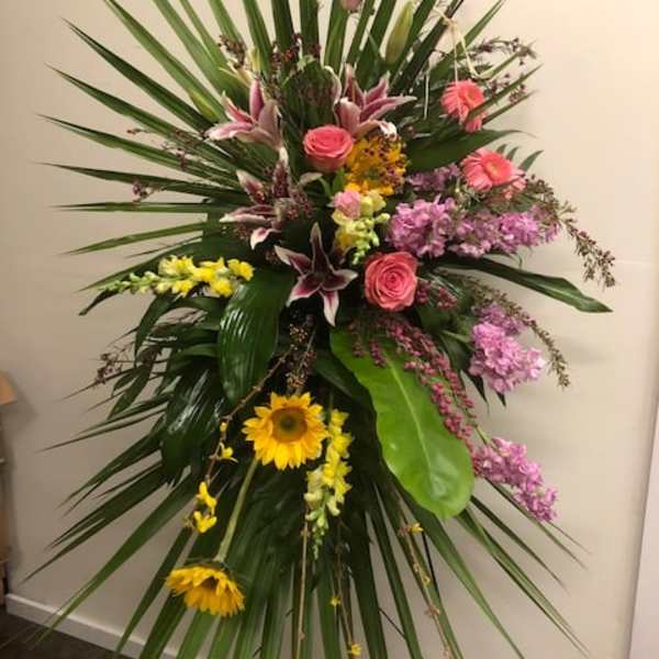 Tall standing floral spray with pink, yellow, and purple flowers