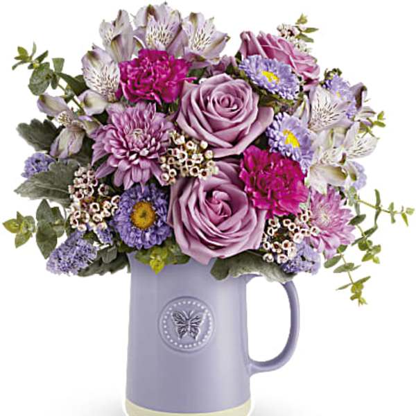 Lavender and pink mixed bouquet in a purple pitcher vase