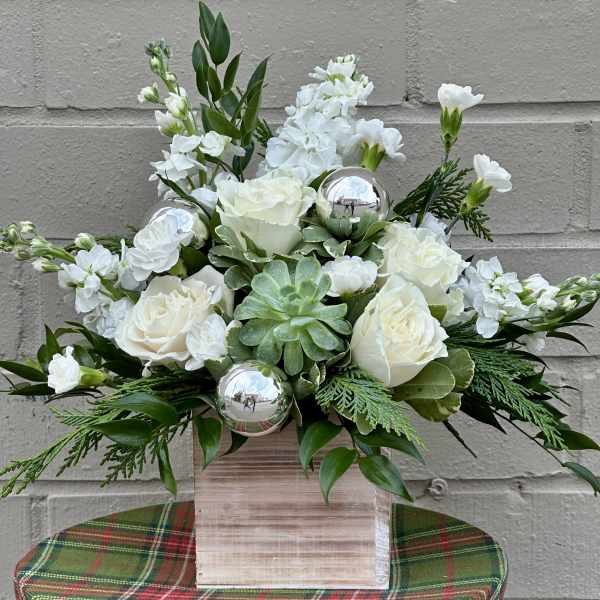 White roses and carnations in a wooden box with silver ornaments