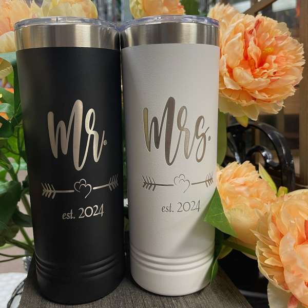 Two engraved tumblers with peach flowers around them