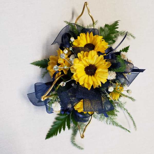 Yellow daisy corsage with navy ribbon and gold accents