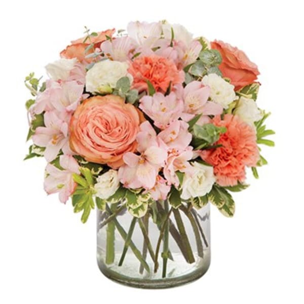 Peach and pink mixed bouquet in a clear glass vase