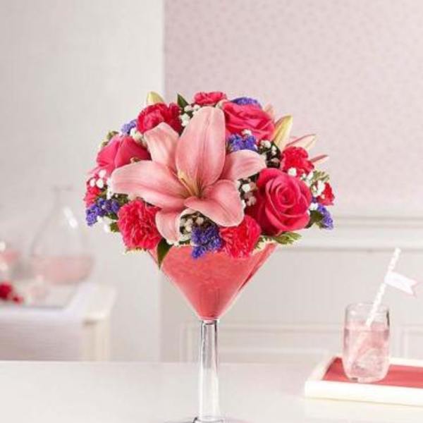 Pink lily and rose arrangement in a tall glass vase