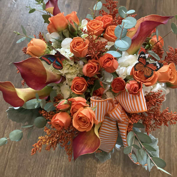 Orange roses and calla lilies with butterflies and a striped ribbon