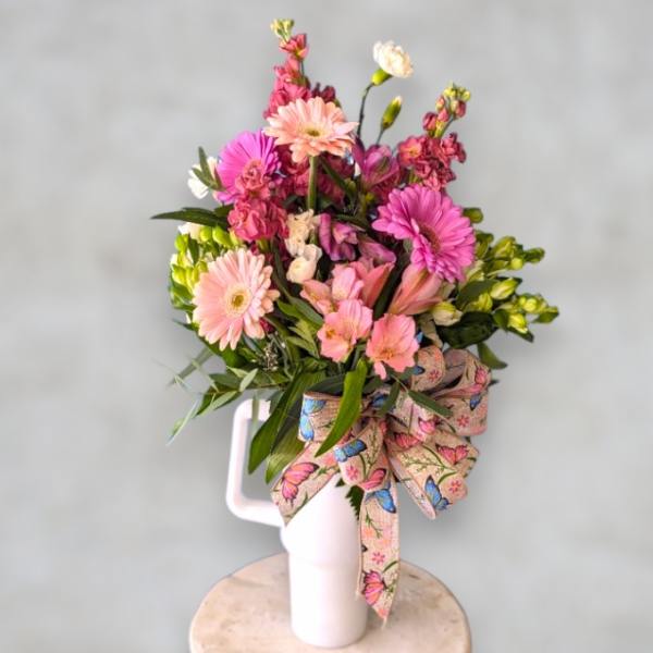 Pink and peach mixed bouquet in a white vase with a butterfly ribbon