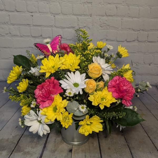 Yellow and white daisy bouquet with pink carnations in a metal bucket