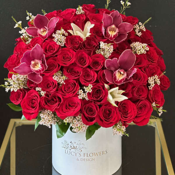 Red rose arrangement with orchids in a white hat box