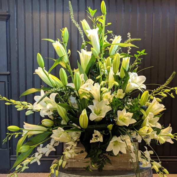 Large white lily arrangement in a clear vase