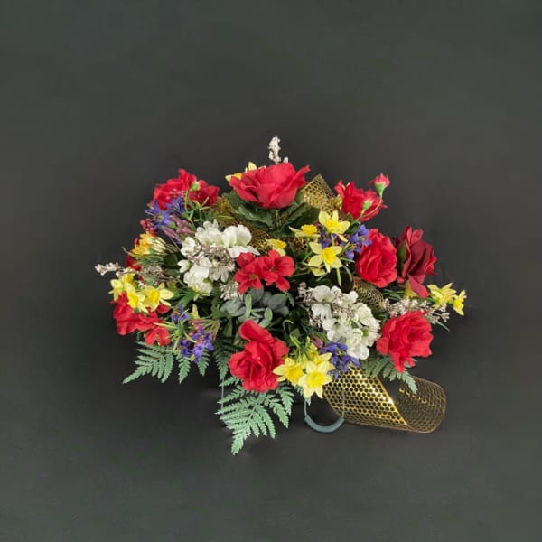 Colorful bouquet of red, white, yellow, and purple flowers with gold ribbon