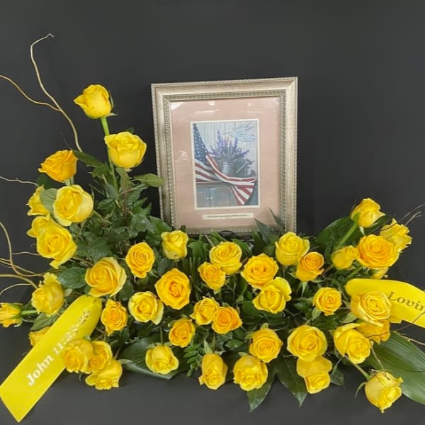 Yellow rose funeral spray with framed tribute and ribbons