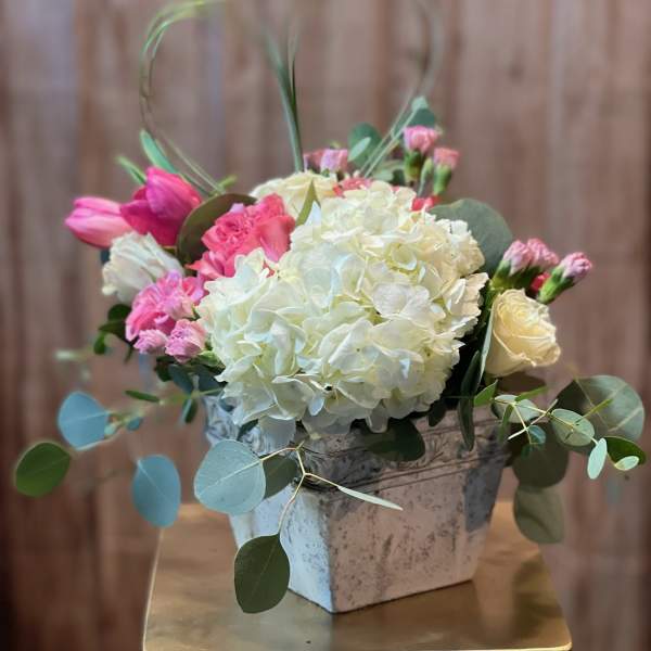 Pink and white floral arrangement in a square vase