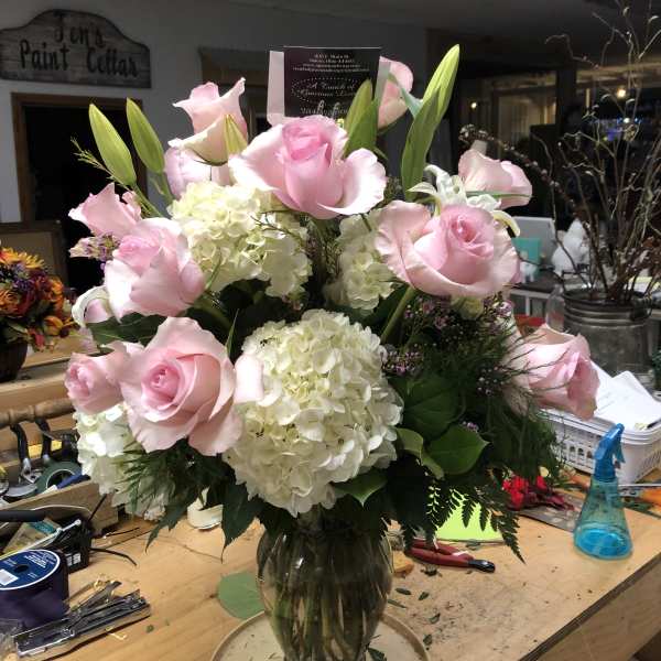 Pink roses and white hydrangeas arranged in a glass vase