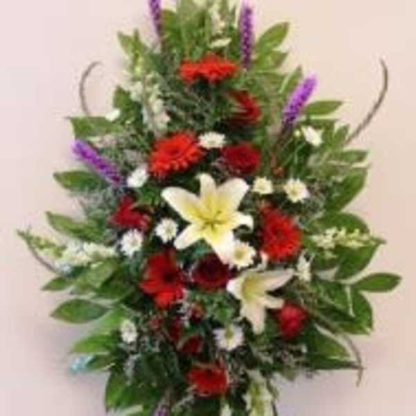 Standing floral spray with red, white, yellow, and purple flowers